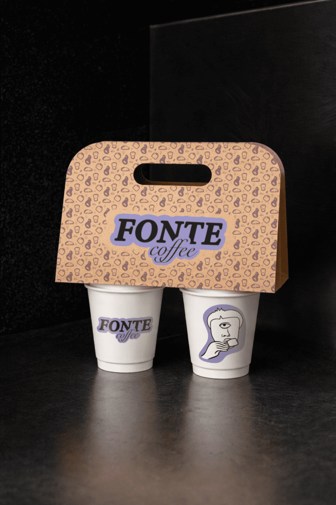 Takeaway coffee cup with FONTE branding photographed in a dark minimal setting
